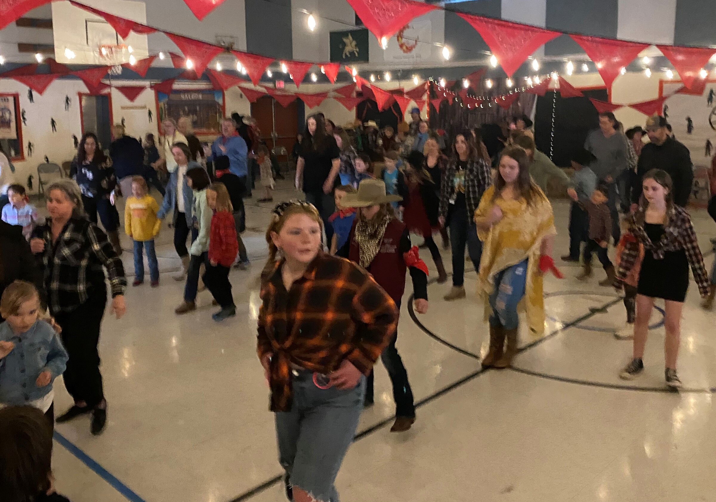 Student linedance leaders with red bandanas help to teach attendies how to do the electric slide